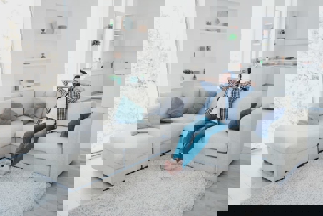 A man reclines on a white couch