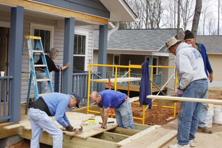 Volunteers build a home's porch