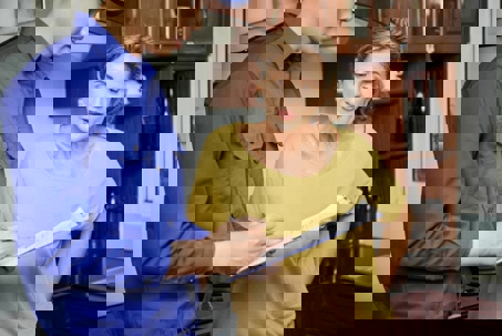 A technician goes over repairs with a woman