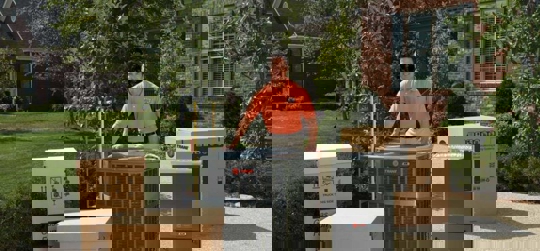 A man stands next to new HVAC units