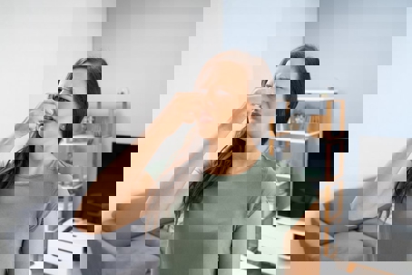 A woman holds her nose, expressing displeasure with an odor