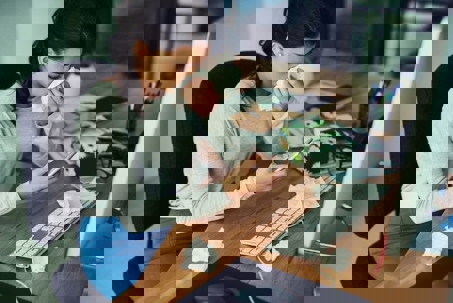 A woman sits at her desk with a tissue