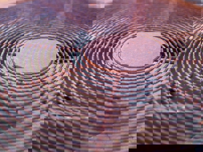 A rusty, round AC unit cover