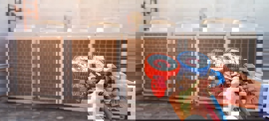 An HVAC technician checks multiple rooftop air conditioning units