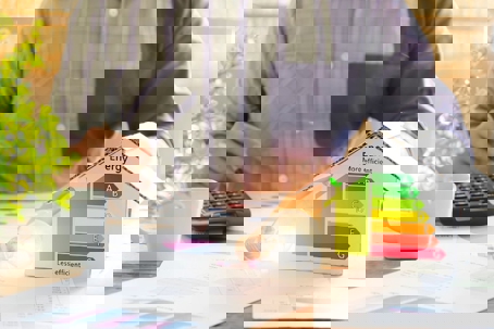 A person is calculating energy efficiency ratings for a home