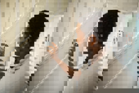 A man adjusting a wall-mounted thermostat