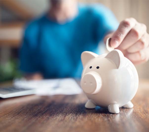 Woman Putting Coin In Piggy Bank